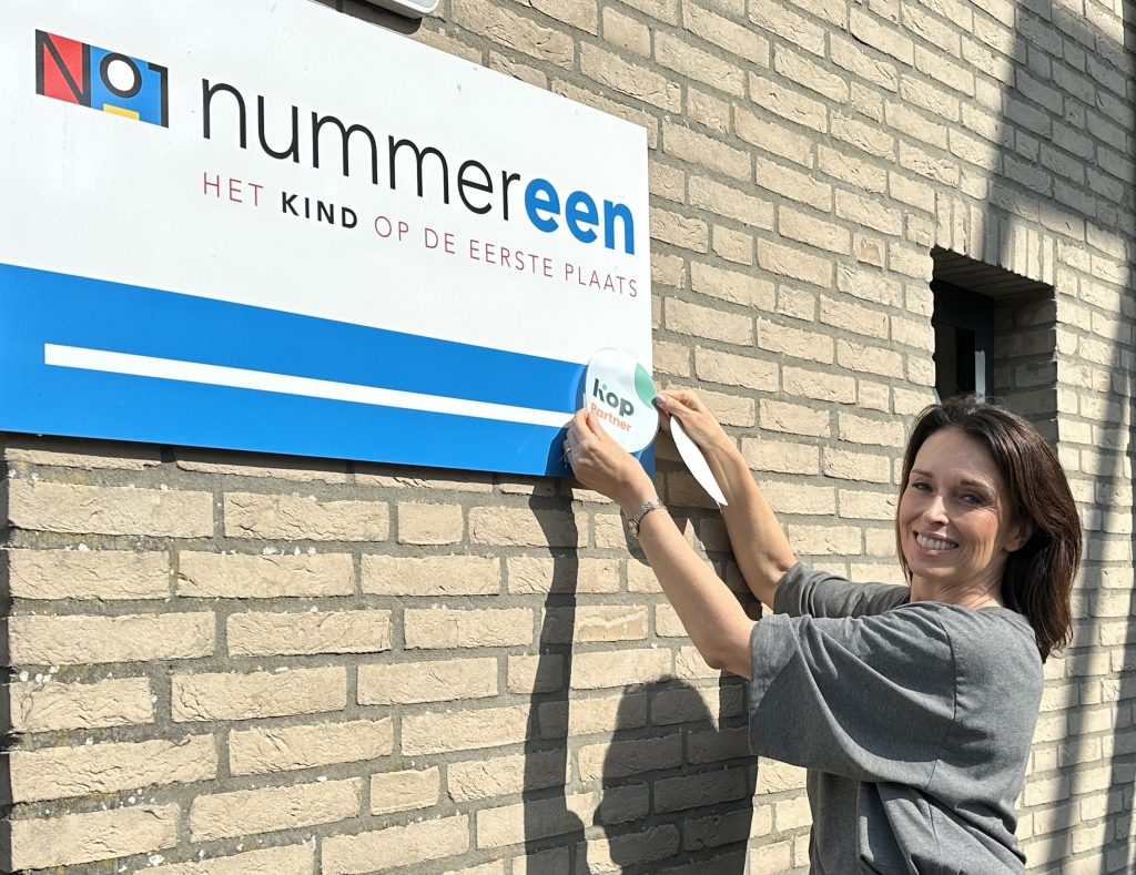 Mevrouw plakt sticker op gebouw